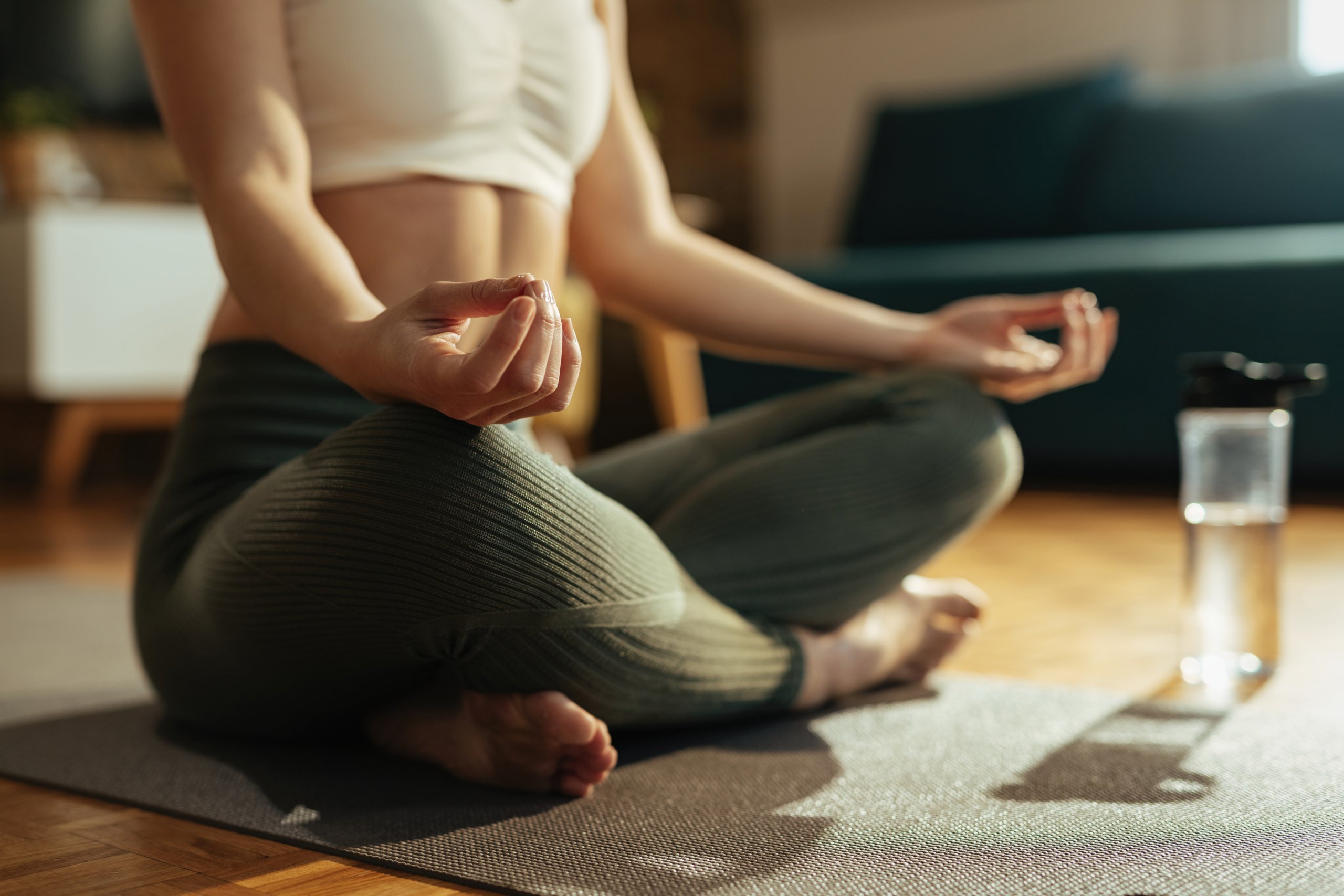 Close-up of athletic woman practicing Yoga in lotus position.